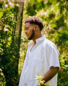 man in white shirt standing among trees